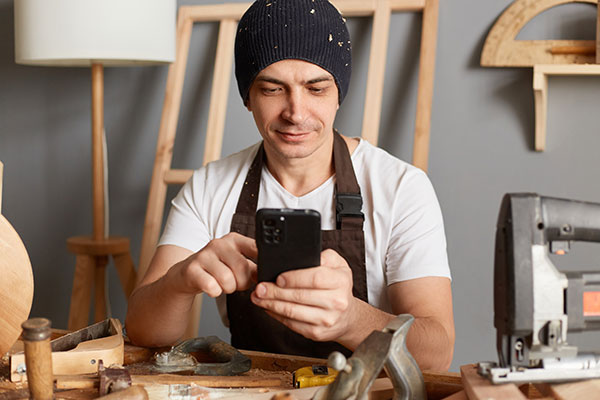 woodworker looking up info with phone